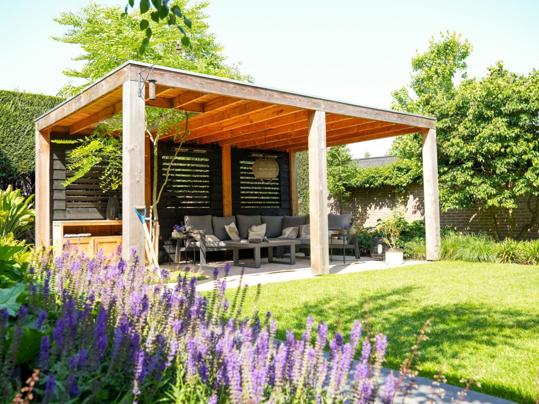 Houten overkapping met loungehoek en lavendel