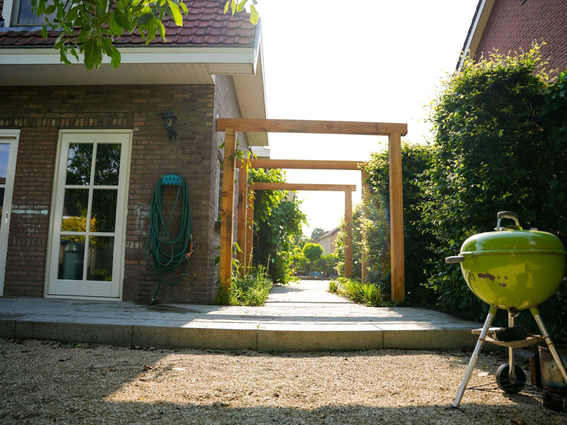 Houten pergola bij de zijgevel