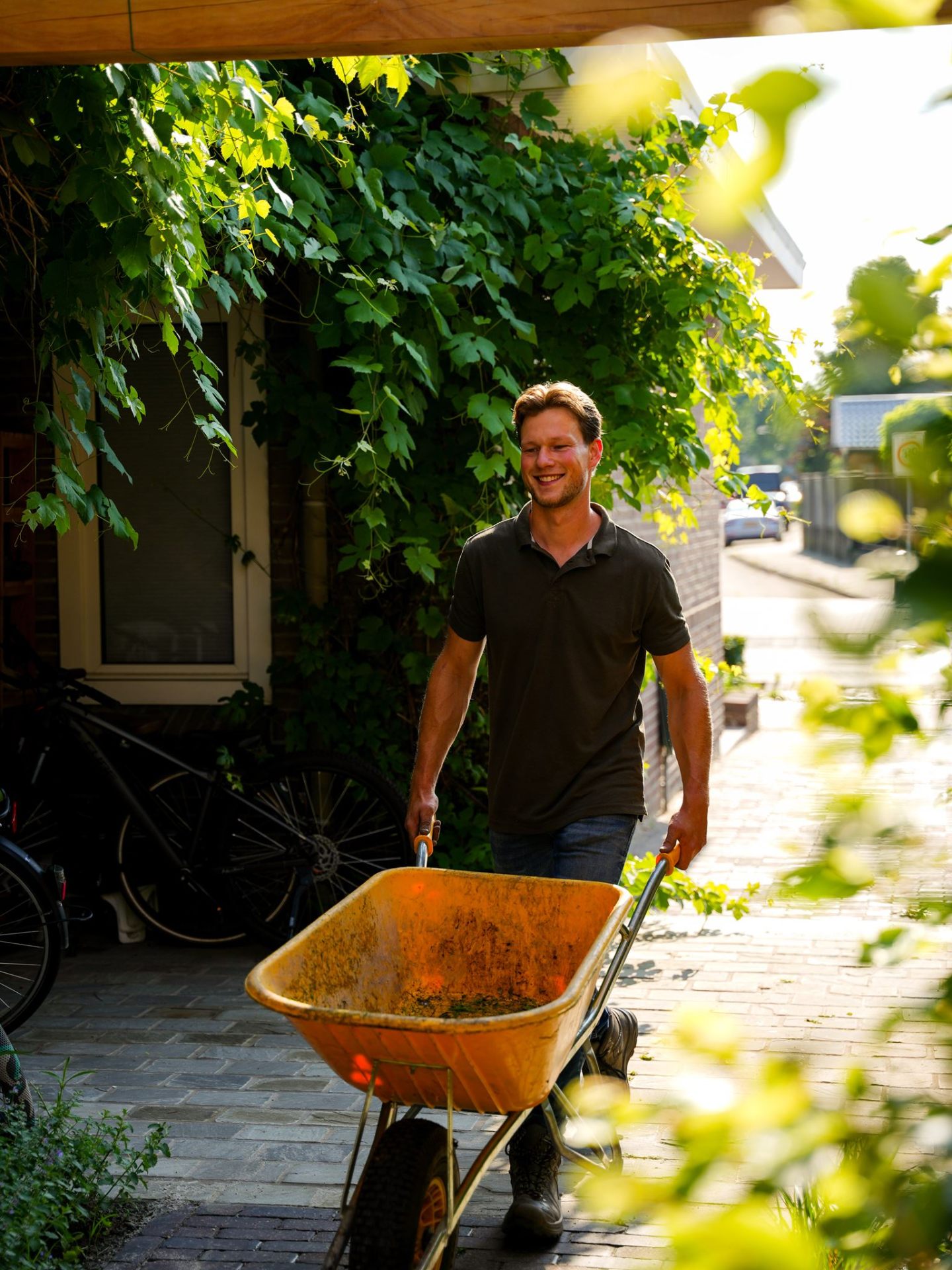 Hovenier met kruiwagen onder de druivenrank