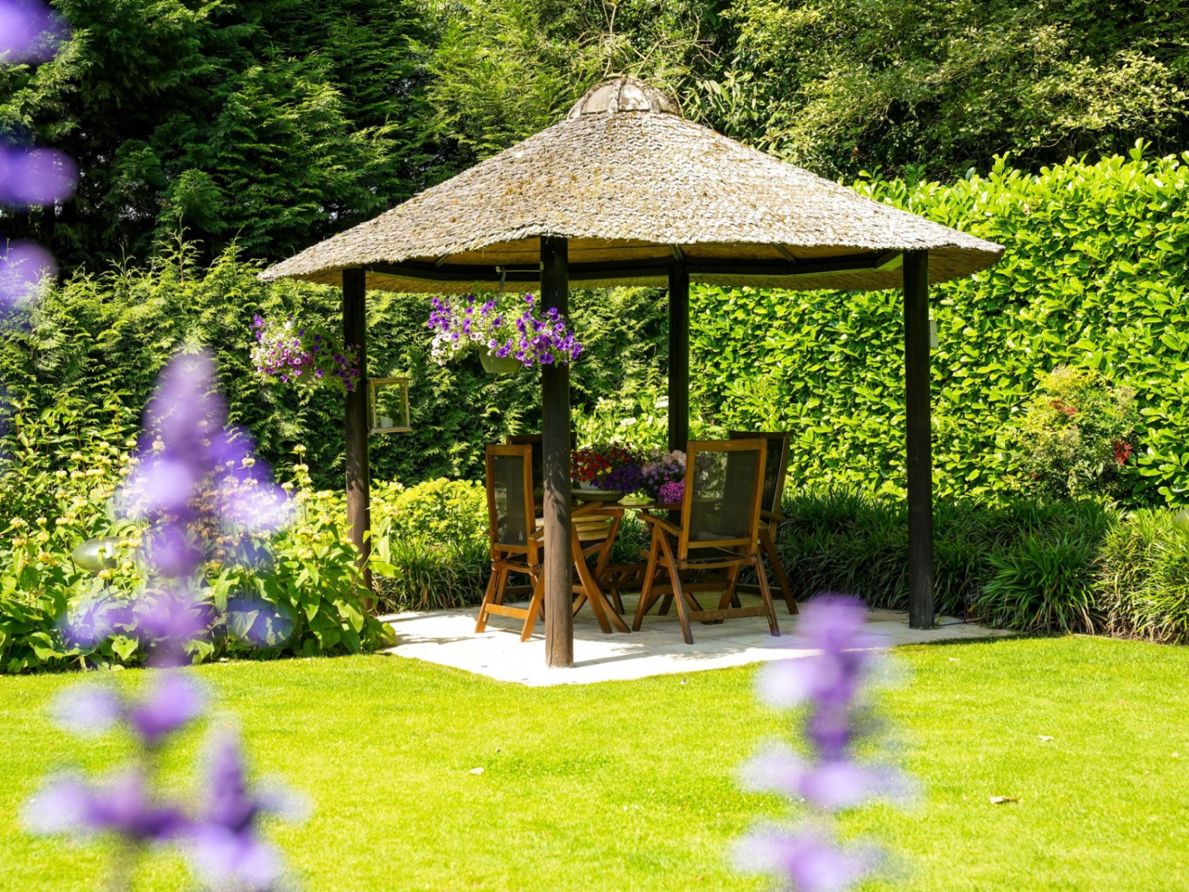 Rieten prieel in een weelderige tuin